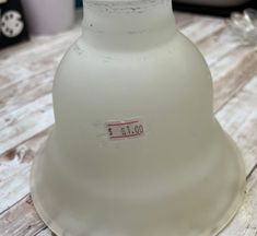 a white bell shaped object sitting on top of a wooden table