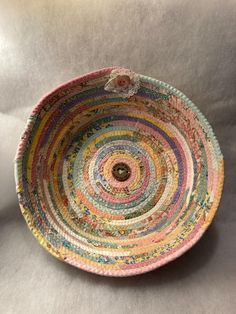 a multicolored bowl with a flower in the center