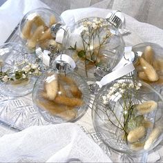 several clear glass ornaments with flowers in them