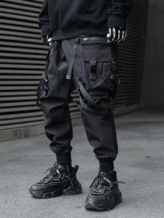 Main: Cotton/poly Adjustable buckle belt fastening Double harness straps Strapped cargo pockets Cuffed hem Concealed nylon side zipped pockets Back pockets STYLE NOTES Cargo pants have become increasingly popular over the last few seasons. And as streetwear continues to grow, these practical trousers are here to stay. Tactical inspired cargo pants are a must have in your rotation. Looser, tapered fits remain key with techwear styles reigning supreme. Pair with other streetwear-leaning staples su How To Style Cuffed Cargo Pants, Cuffed Cargos, Black Men Streetwear, Techwear Cyberpunk, Cargo Pants Streetwear, Cargo Pants Style, Streetwear Spring