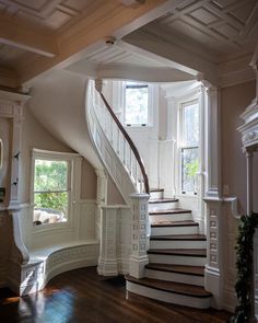 a staircase leading up to the second floor in a house with white walls and wood floors