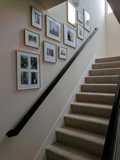 a staircase with pictures on the wall above it