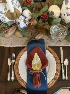 the table is set with blue and white dishes, silverware, and napkins