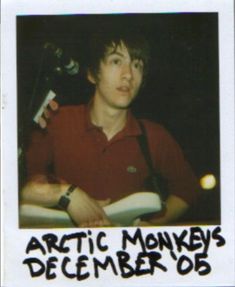 a man holding a book in his right hand with the words arctic monkey's december 05 on it