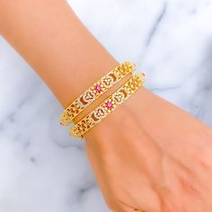 This pair of 22k gold bangles, with a total weight of 44.5 grams, features a radiant and impressive design, adorned with cubic zirconia stones that highlight the intricate floral patterns set in a gleaming yellow gold finish. The bangles are sized at 2.5, with an opening diameter of 2.3 inches, ensuring a comfortable fit for the wearer. Comprising two pieces, this set exemplifies luxury and elegance, perfect for those who appreciate the blend of traditional floral motifs with the sparkling allure of cubic zirconia. Ideal for adding a touch of sophistication to any ensemble, these bangles are a testament to exquisite craftsmanship and timeless style. PRODUCT DETAILS Gold Purity(karat): 22k Gold Weight(grams): 44.5 Item Finish: Yellow Gold Stone: Cubic Zirconia Bangle Size: 2.5 Bangle Openin Gold Bangle With Intricate Design In Cubic Zirconia, Gold Bangle With Intricate Cubic Zirconia Design, 22k Gold Bangles, The Bangles, Gold Stone, Floral Motifs, 22k Gold, Floral Patterns, Gold Bangles