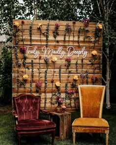 an old chair sitting next to a wooden wall with flowers on it and the words truly madly deeply written in white