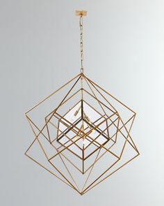 a gold chandelier hanging from a ceiling with white walls in the back ground