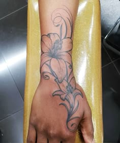 a person's hand with a flower tattoo on it