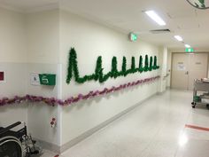 a hospital hallway decorated with green letters and flowers on the wall next to a wheel chair