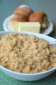 there is a bowl of rice and rolls on the table