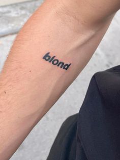 a man's arm with the word blond tattooed on it, in black ink