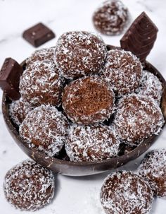 a bowl filled with chocolate covered pastries on top of a table