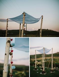 an outdoor ceremony setup with white fabric and flowers on the trees, blue cloth draped over it