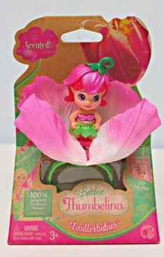 the little mermaid doll has pink hair and is sitting on top of a large flower