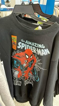 a spiderman sweatshirt hanging on a rack in a store