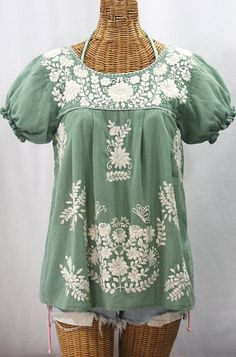 "* Ornate hand embroidery and traditional puff sleeves, available here in SAGE with CREAM embroidery. * Light, gauzy and semi-sheer 100% cotton throughout; wear it billowy and flowing in the traditional bohemian style. * Dyed, distressed and embroidered entirely by hand for an authentic, retro-vintage and hippie casual vibe. * Our ornate butterfly floral embroidery patterns are a faithful tribute to the original Mexican style hippie blouses of the 1970's. * Caringly embroidered by hand, each top Mexican Peasant Blouse, Embroidery Light, Cream Embroidery, Kurti Embroidery, Hippie Blouse, Mexican Blouse, Embroidery On Kurtis, Sup Yoga, Kurti Embroidery Design