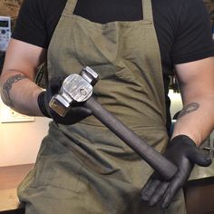 a man in an apron is holding a hammer