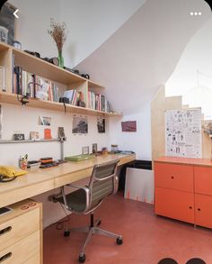 a room with a desk, chair and bookshelf in the middle of it