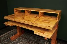 a wooden desk sitting on top of a rug in front of a green painted wall