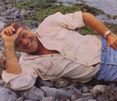 a man laying on the ground next to some rocks