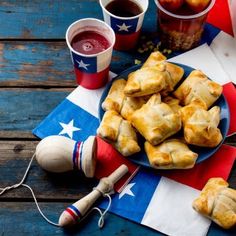 patriotic desserts and drinks on a picnic table with american flag napkin, utensils