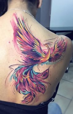 the back of a woman's shoulder with a colorful bird tattoo on it