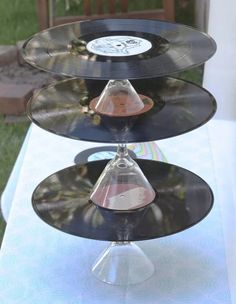 three records are stacked on top of each other at an outdoor table with grass in the background