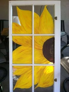 a sunflower painted on the side of a glass door