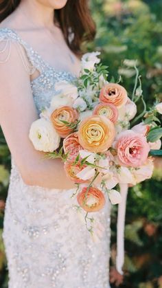 a woman holding a bouquet of flowers in her hand and wearing a dress with sequins on it