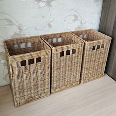 three wicker baskets sitting next to each other on a wooden floor in front of a wall