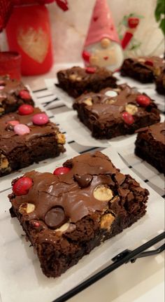 chocolate brownies with m & m candies and candy on top are sitting on a cooling rack