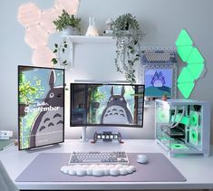 two computer monitors sitting on top of a desk next to an apple keyboard and mouse