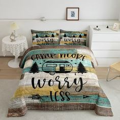 a bed covered in a comforter and pillows with the words camping is very nice