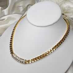 Gorgeous vintage gold tone necklace features a pave set rhinestone center, fastened with two lengths of heavy, shiny Cuban chain. Lobster clasp closure. There is a definite stamp on the back, but am unable to discern. A beautiful piece in excellent pre-loved condition! Party Chain Necklace With Rhinestones In Cuban Link, Cuban Link Chain Necklace With Rhinestones For Party, Gold Chain Link Rhinestone Necklace For Party, Elegant Rhinestone Cuban Link Chain Necklace, Elegant Rhinestone Cuban Link Necklaces, Elegant Cuban Link Rhinestone Necklaces, Elegant Rhinestone Cuban Link Necklace, Elegant Cuban Link Necklace With Rhinestones, Gold Cuban Link Necklace With Rhinestones