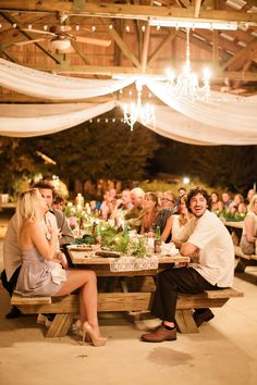 a group of people sitting around a wooden table