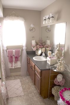 a bathroom with pink and white decor on the walls, tile flooring and sink