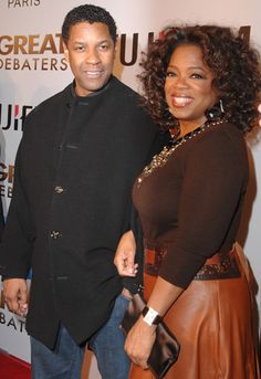 a man standing next to a woman on a red carpet