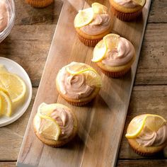 cupcakes with frosting and lemon slices on a cutting board