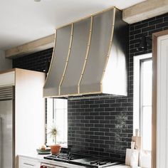 a stove top oven sitting inside of a kitchen under a metal hood over it's burners