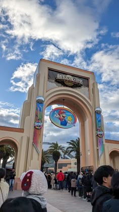 people are standing in front of the entrance to an amusement park