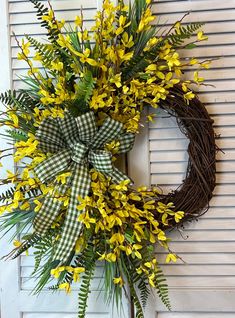 a wreath with yellow flowers hanging on a door