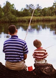 two young boys sitting on a log fishing