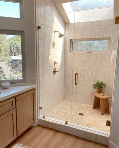 a bathroom with a walk in shower next to a window