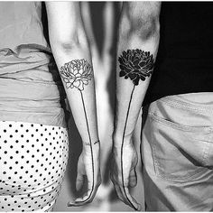 black and white photo of two people with matching tattoos on their legs, both holding hands