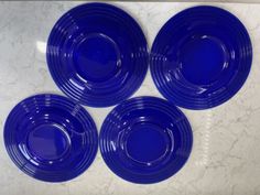 four blue plates sitting on top of a white counter