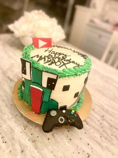 a decorated cake sitting on top of a table next to a video game remote control