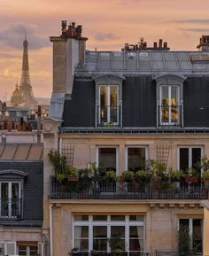 the eiffel tower is seen in the distance from this building's rooftop