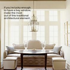 a living room filled with furniture and a chandelier hanging over a wooden table