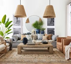 a living room filled with lots of furniture next to a mirror and potted plant