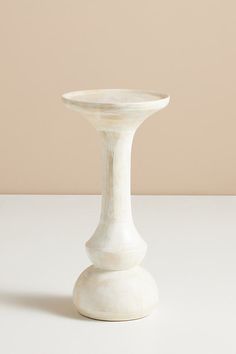 a white vase sitting on top of a table